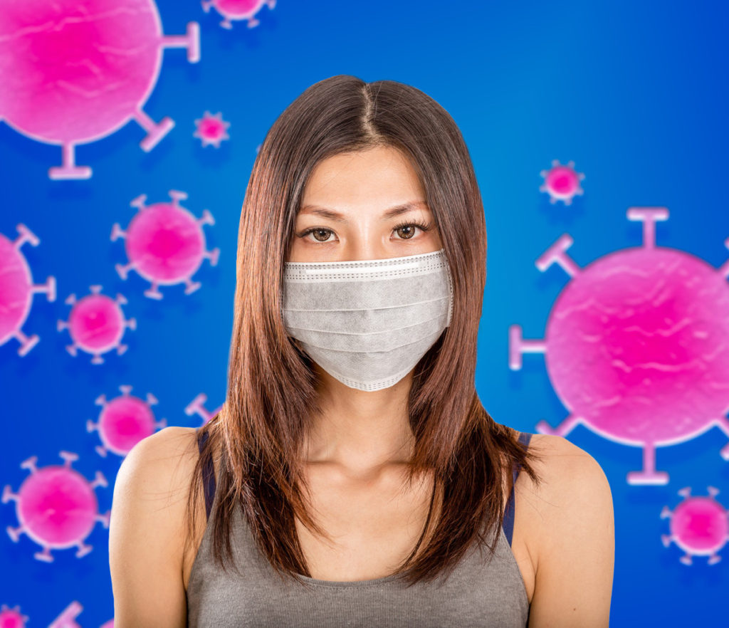 Woman wearing mask with a background of coronavirus germs.